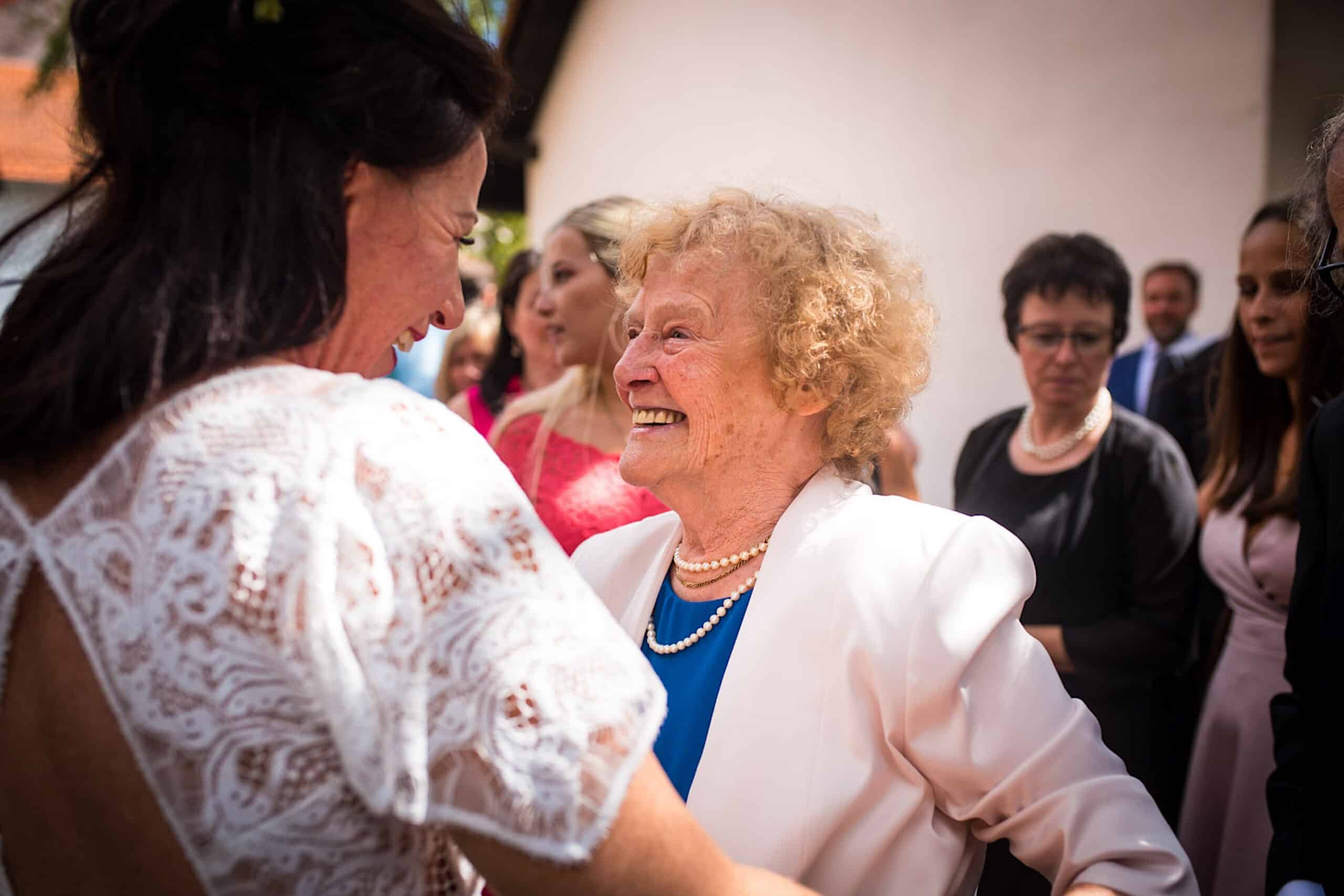 Ältere Frau gratuliert der Braut zur Eheschließung