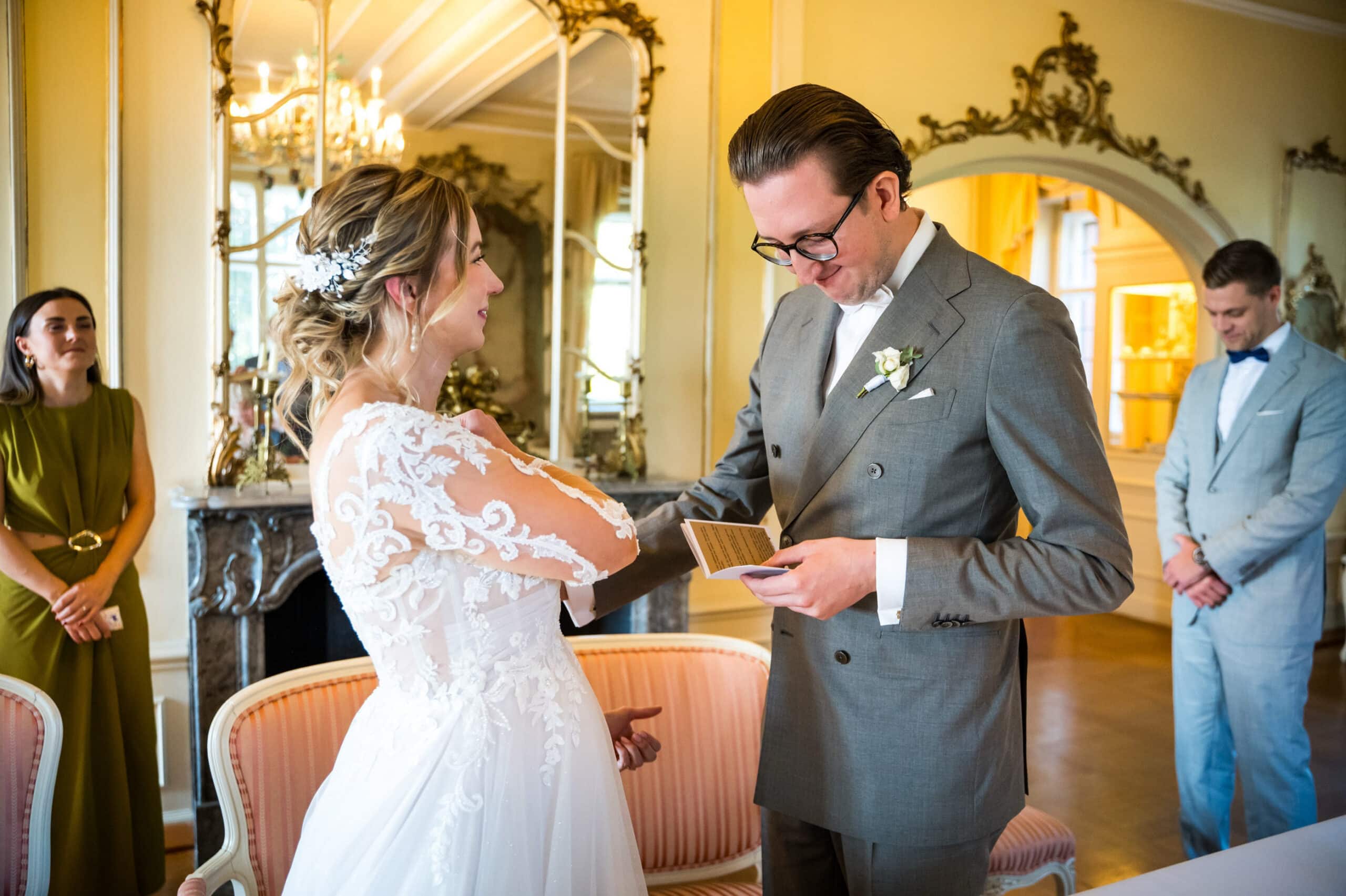 Brautpaar steckt sich die Eheringe im Schloss Vollrads Trausaal an