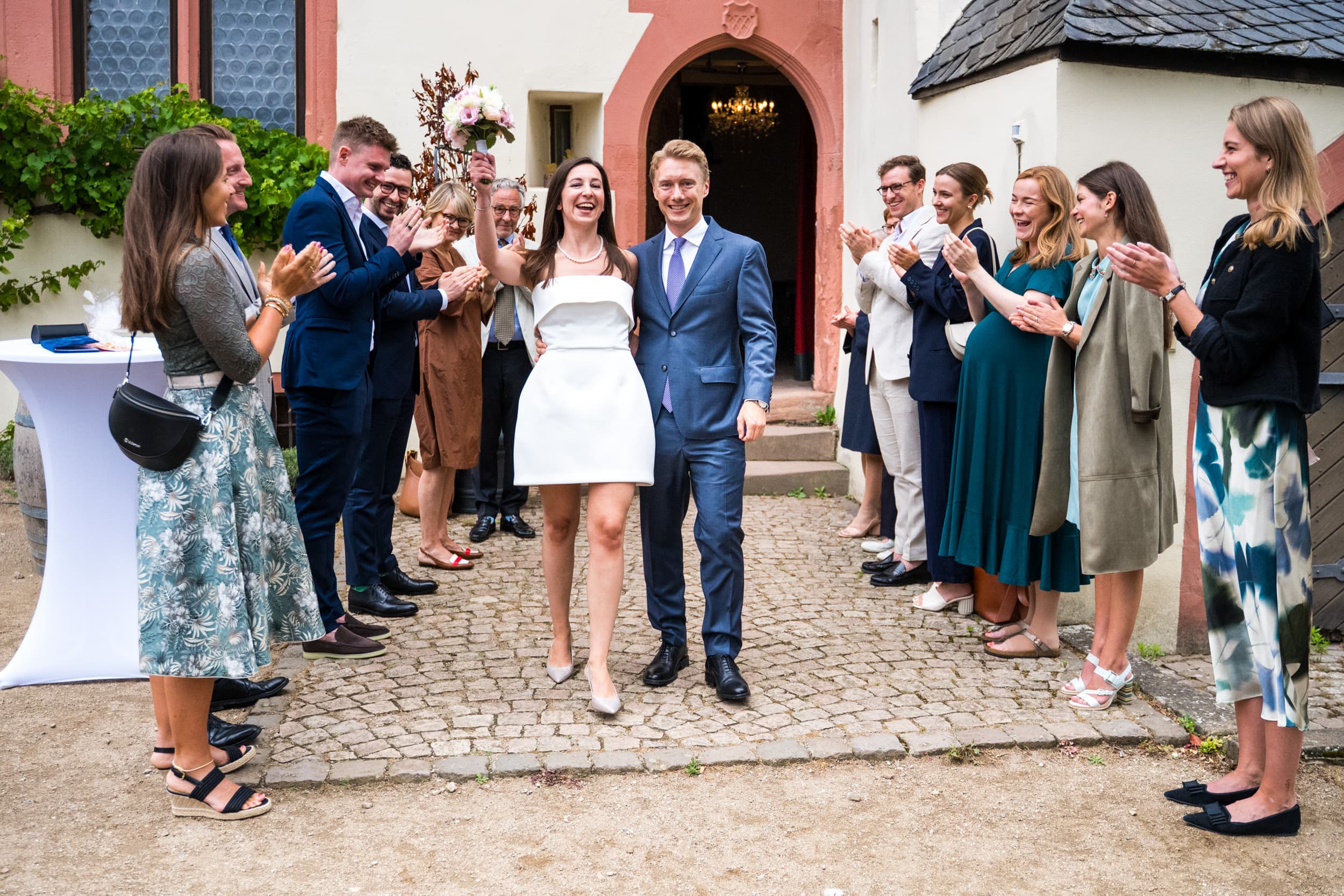 Gäste bilden einen Spalier im Freien auf Schloss Schönborn in Geisenheim und Brautpaar zieht aus